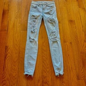 AMERICAN EAGLE NEXT LEVEL STRETCH DISTRESSED ROW HEM MID RISE LIGHT BLUE SIZE 00